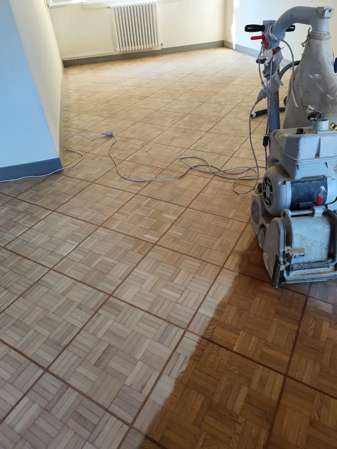 Ponçage parquet en cours — machine professionnelle